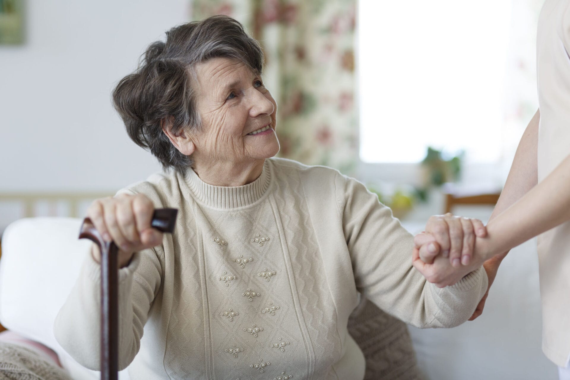 78146344 - smiling senior woman holding a cane and looking at her caregiver